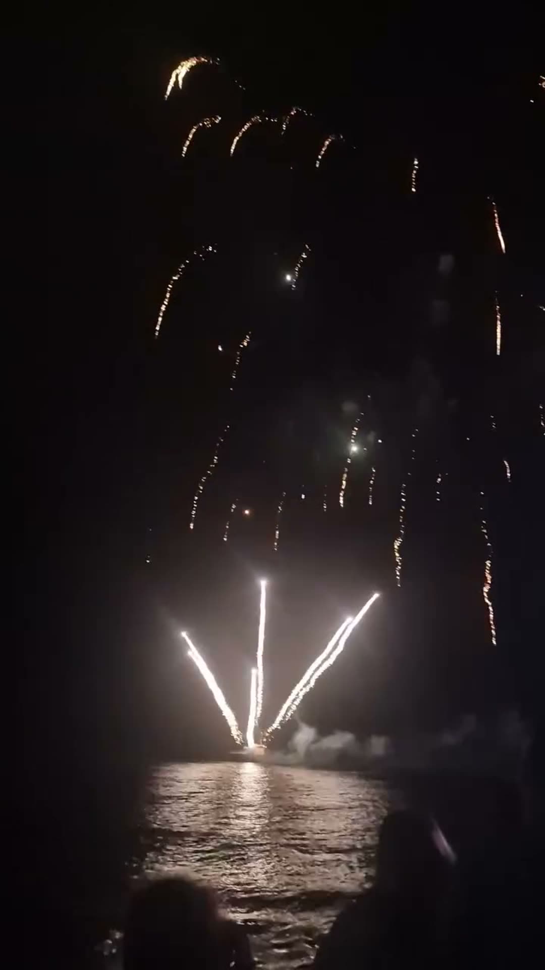 Bournemouth Friday fireworks firing from the sea platform east of the pier, reflected in the water