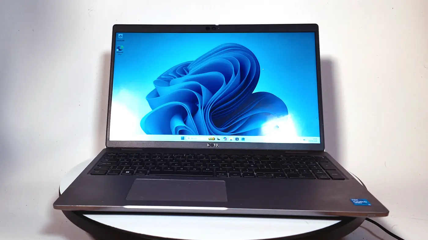 A refurbished Dell Latitude 5520 laptop, open, seen from the front with Windows 11 on the screen